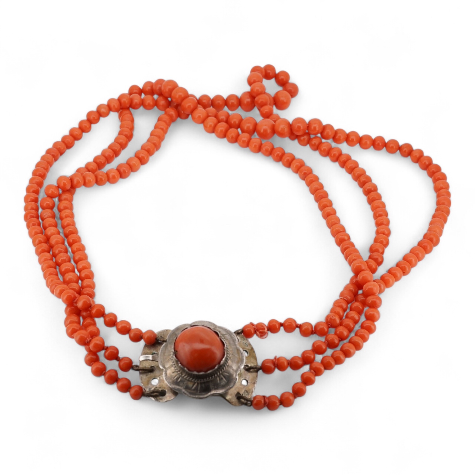A triple strand graduated coral bead choker necklace, with a cabochon coral set white metal clasp, 38cm.